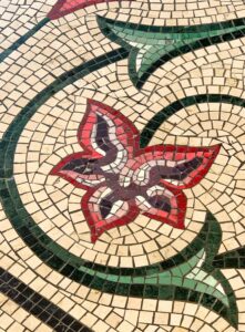 Vibrant floral mosaic pattern with intricate stone tiles creating artistic decoration.