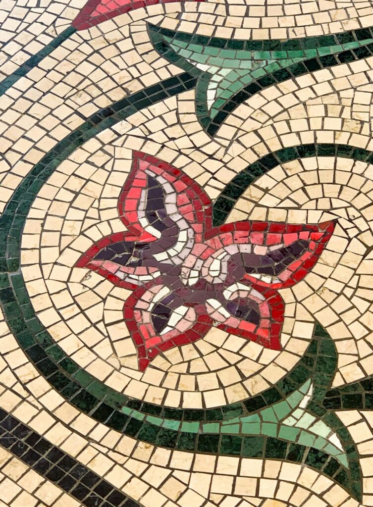 Vibrant floral mosaic pattern with intricate stone tiles creating artistic decoration.